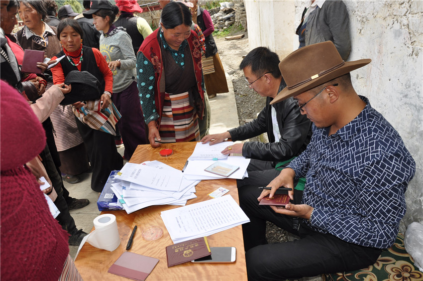 農行理塘縣支行客戶經(jīng)理下鄉(xiāng)辦理扶貧貸款.jpg