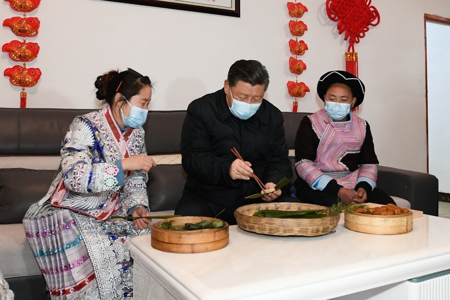 2021年2月3日下午，習近平在貴州畢節(jié)市黔西縣新仁苗族鄉(xiāng)化屋村苗族村民趙玉學家，同一家人邊聊家常邊制作當?shù)貍鹘y(tǒng)節(jié)日食品黃粑。新華社記者 李學仁 攝